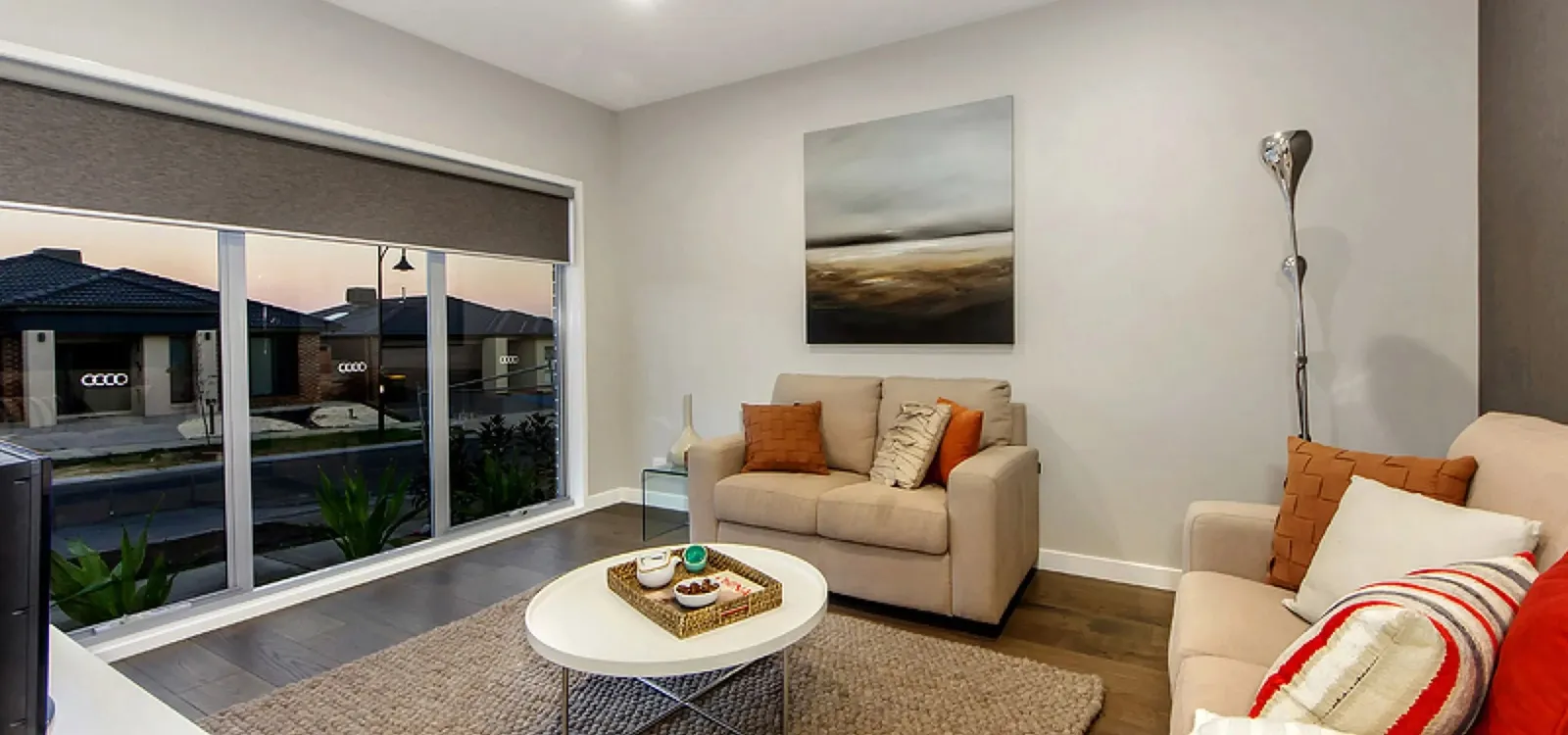 Living room with a beige sofa, round coffee table and a large picture window