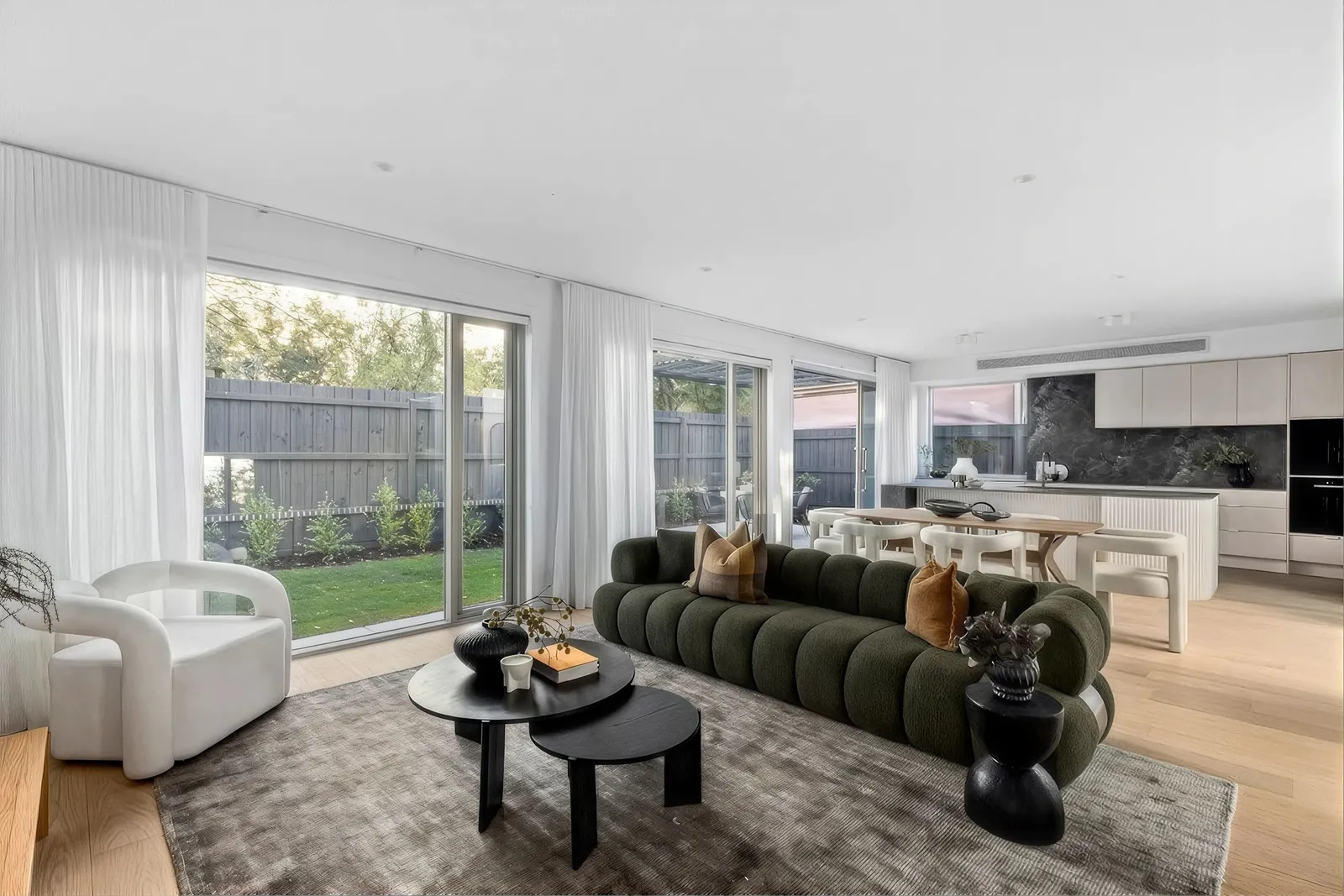 Open-plan living with a green sofa and sliding doors to the garden